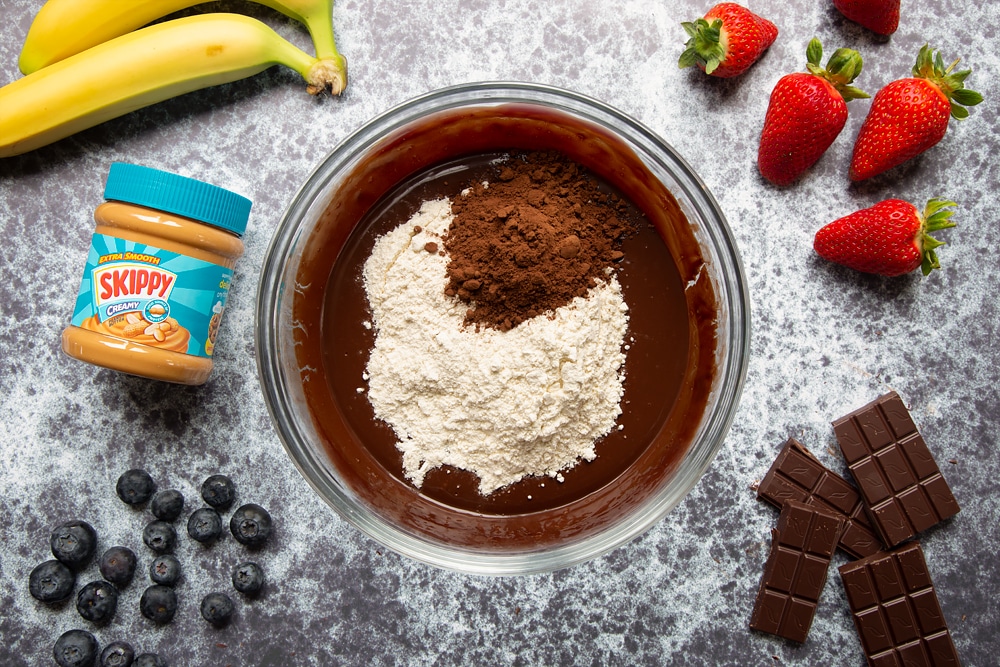 The bowl of mixture now has the additional cocoa and flour ready for the peanut butter brownies