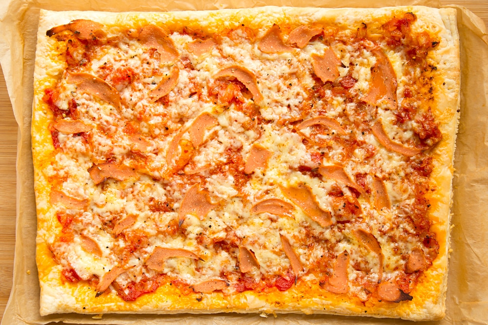 Overhead shot of cooked puff pastry pizza in a baking tray