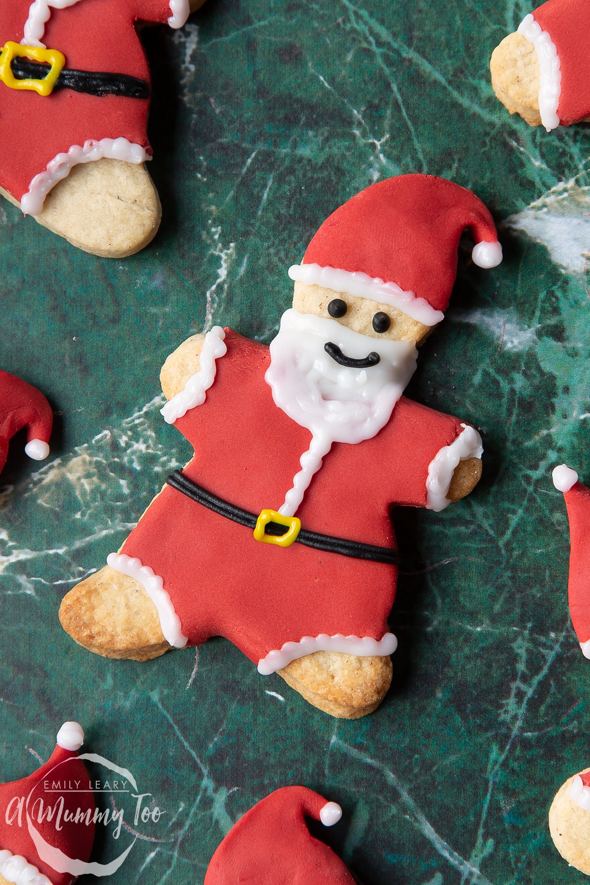 Close up of aFather Christmas cookies on a green marble surface.
