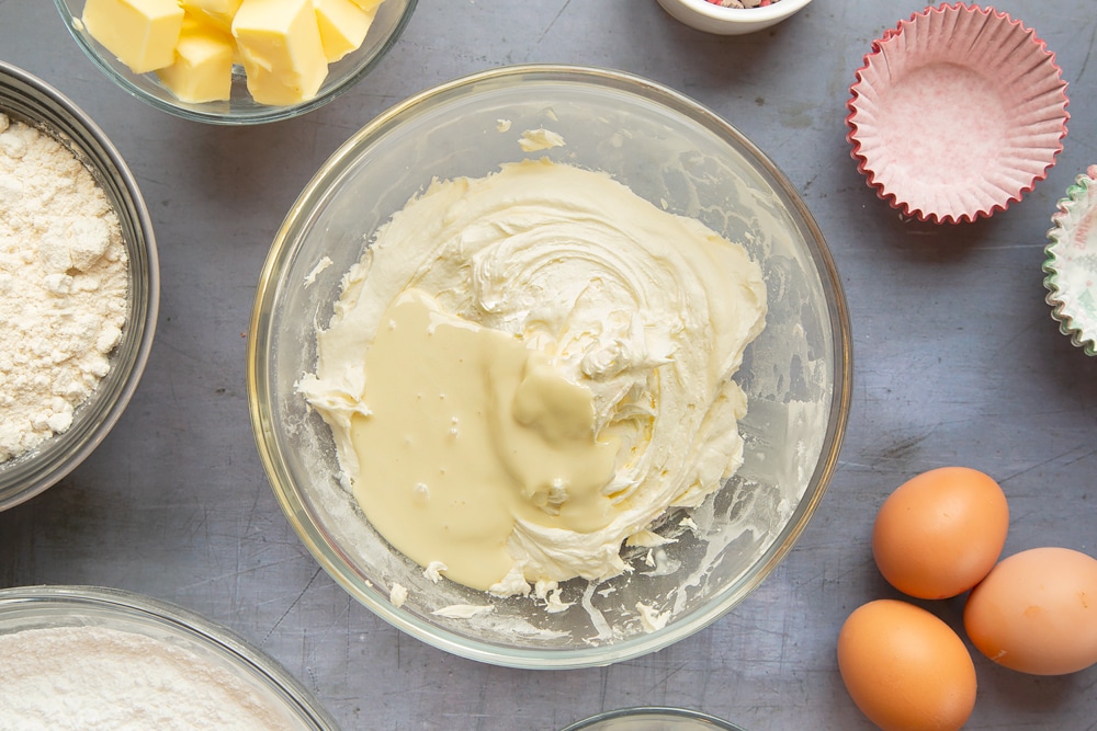Overhead shot of adding the white chocolate to the mixture in the bowl and stiring it together.