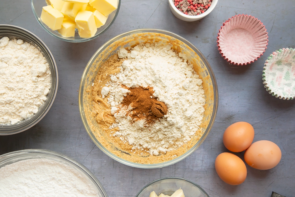 Overhead shot of adding the flour into the mixture for the spiced Christmas cupcakes with marzipan frosting sponge.