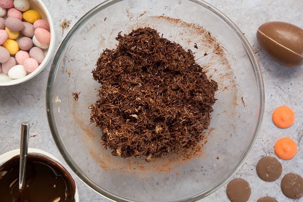 Melted chocolate mixed with shredded wheat, shown alongside mini eggs and a Kinder egg