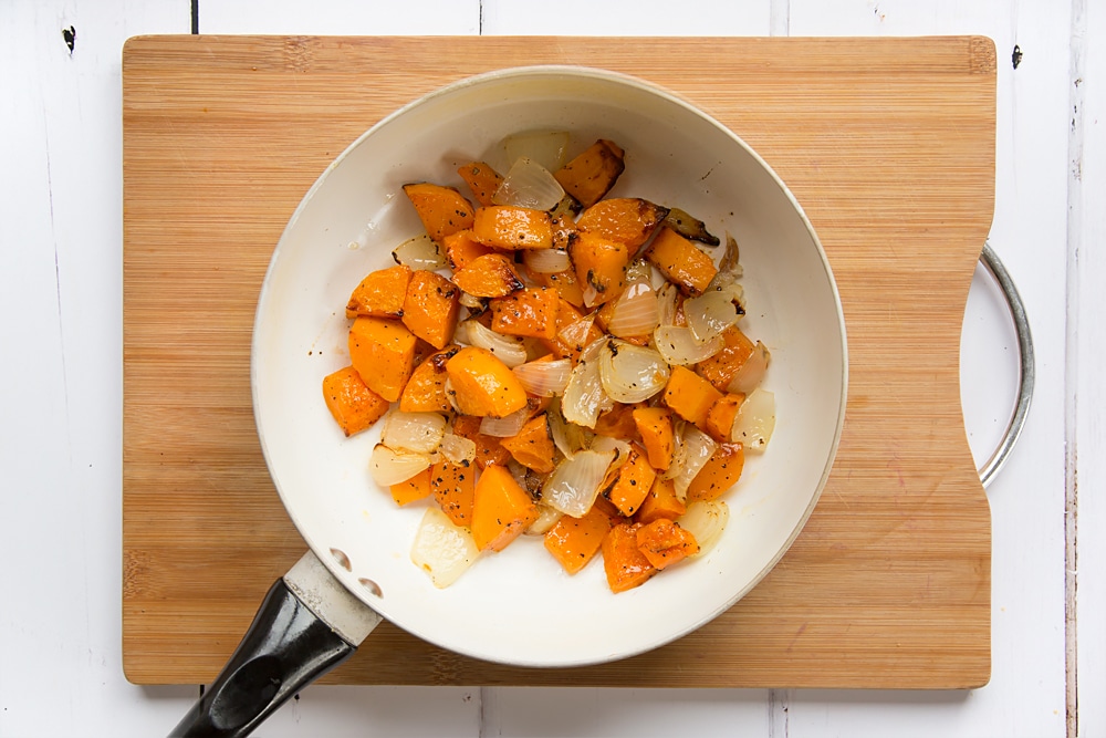 roasted butternut squash soup ingredients in a pan.