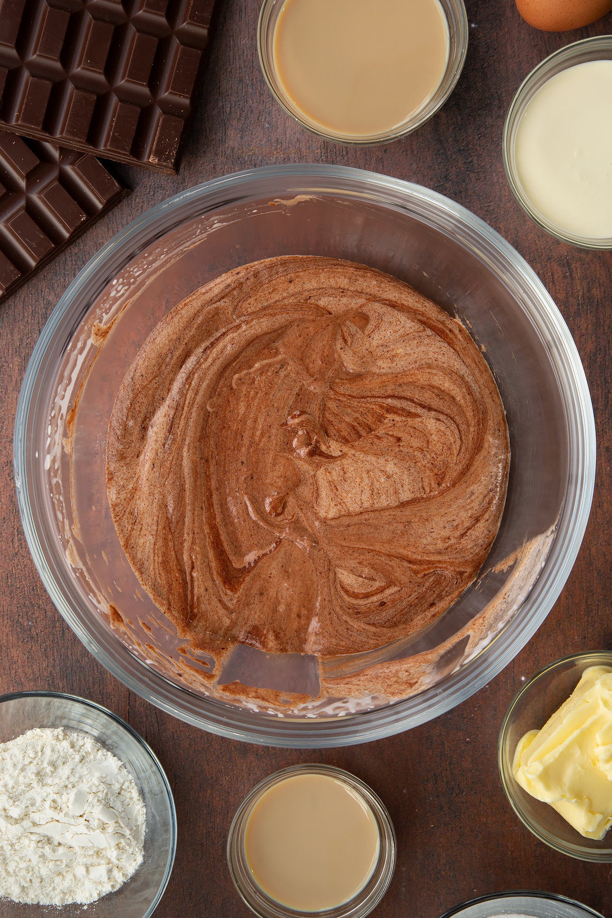 melted chocolate mix with creamy butter mix mixed together in a large clear bowl.