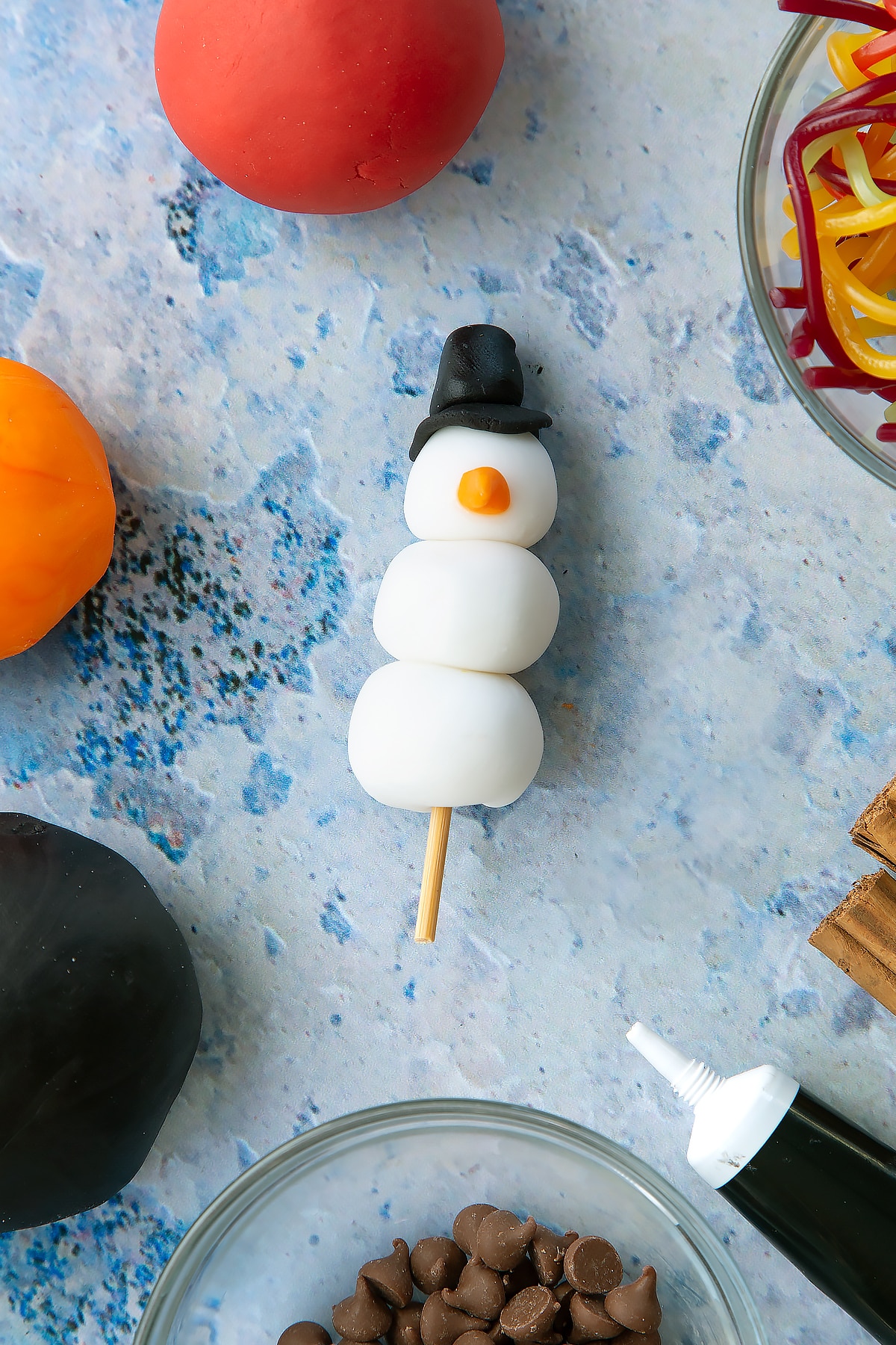 Overhead shot of the snowman made out of sugar paste that will sit on top of the snowman cupcakes.