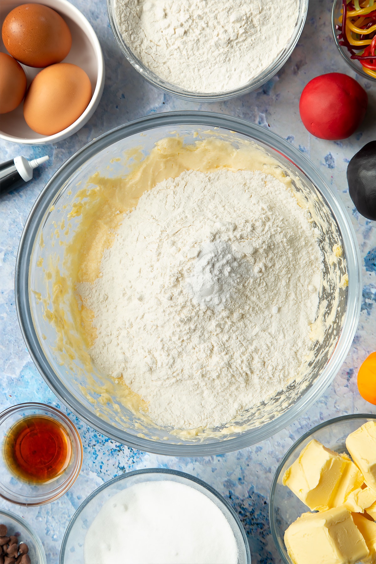 Overhead shot of adding flour and baking powder to the snowman cupcakes mixture.