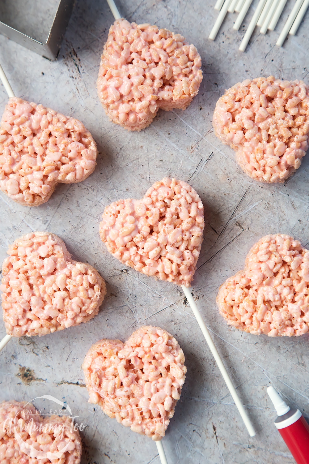 8 heart crispy pops laid on a rough surface.