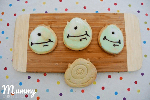 monster inc Mike wazouski sugar cookies and green icing on a wooden chopping board.