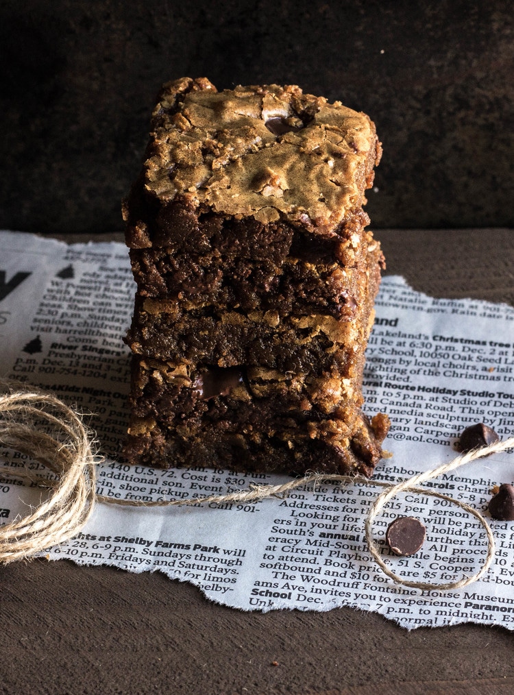 a stack of Gingerbread Espresso Blondies on a newspaper base with string and chocolate chips at the base.