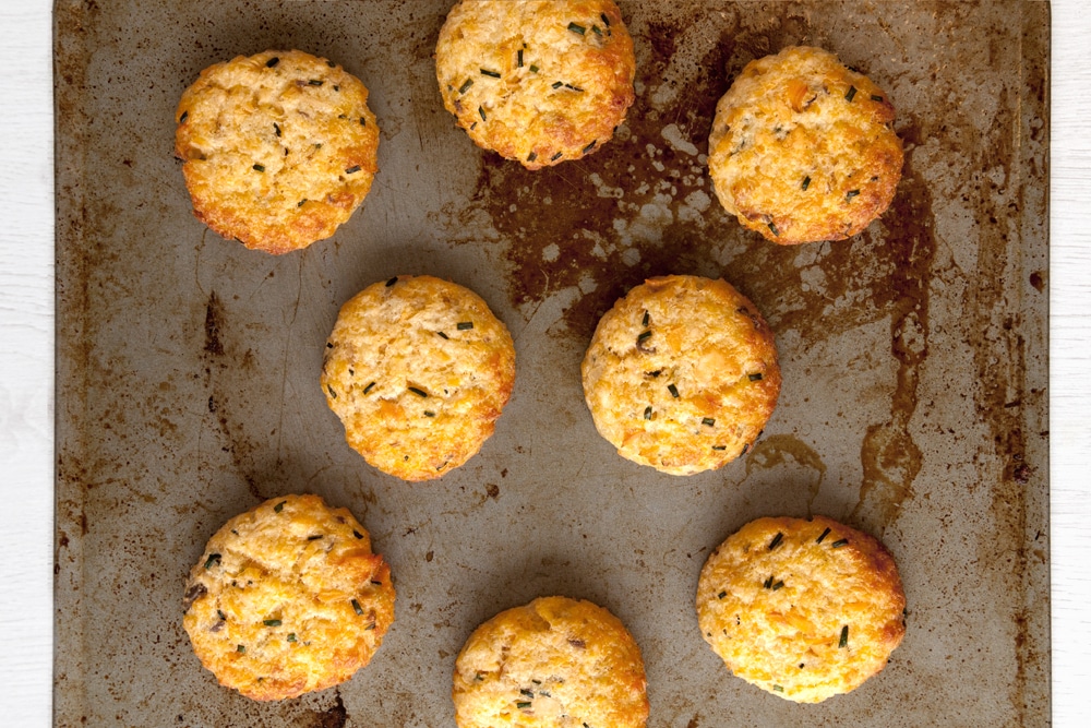 The baked fish cakes without breadcrumbs mixture having been baked in the oven for 20 minutes. The patties sit on a baking sheet.