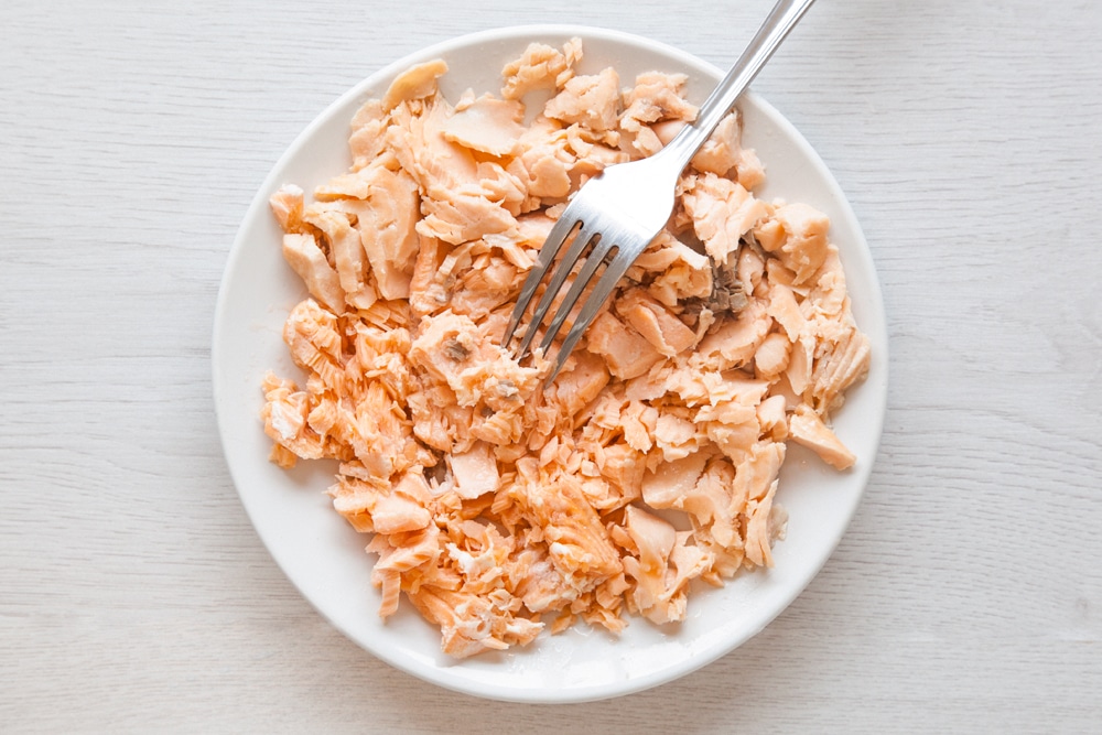The salmon having been flaked using a fork. This salmon will then be used to create the baked fish cakes without breadcrumbs.