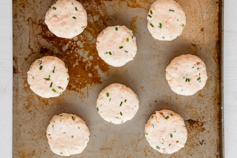 Flattening each of the baked fish cakes without breadcrumbs mixtures to create a pattie like shape.