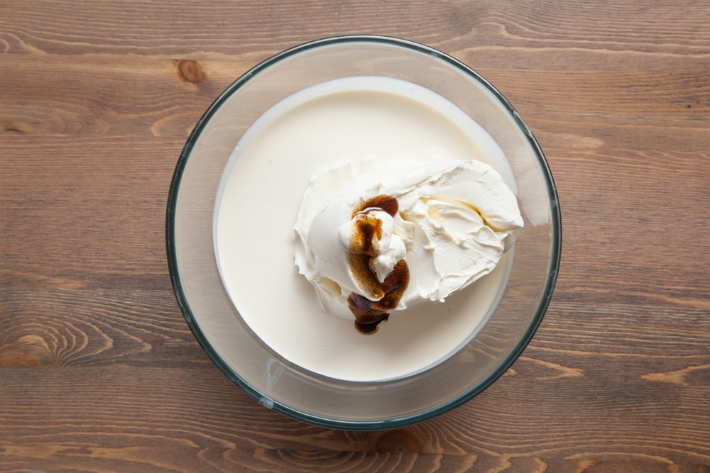A bowl containing cream cheese, double cream and vanilla.