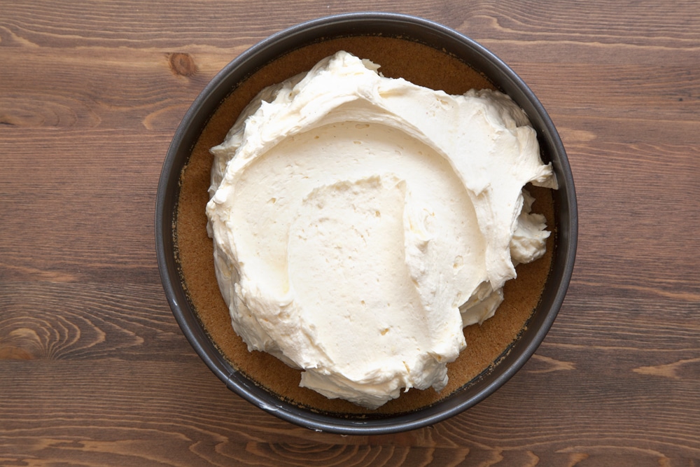 Digestive biscuit crumb mixed with melted butter and tipped into the base of a springform tin. On top is the filling for the white chocolate cheesecake.