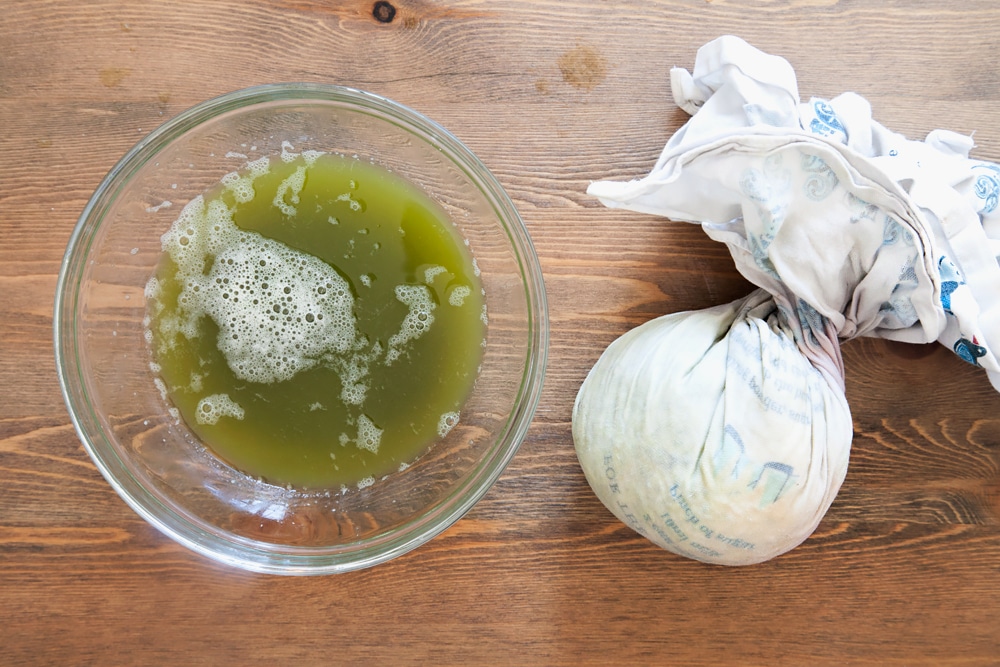 Using a clean cloth to drain the liquid from the vegetables