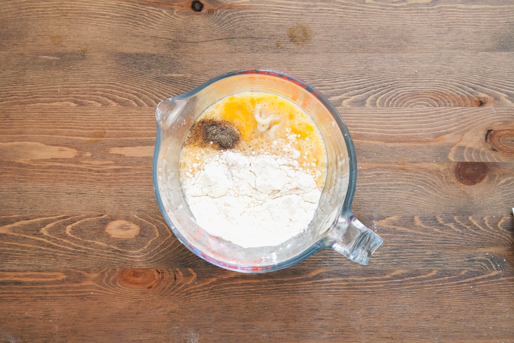 Eggs, flour, garlic and seasoning mixed together in a bowl