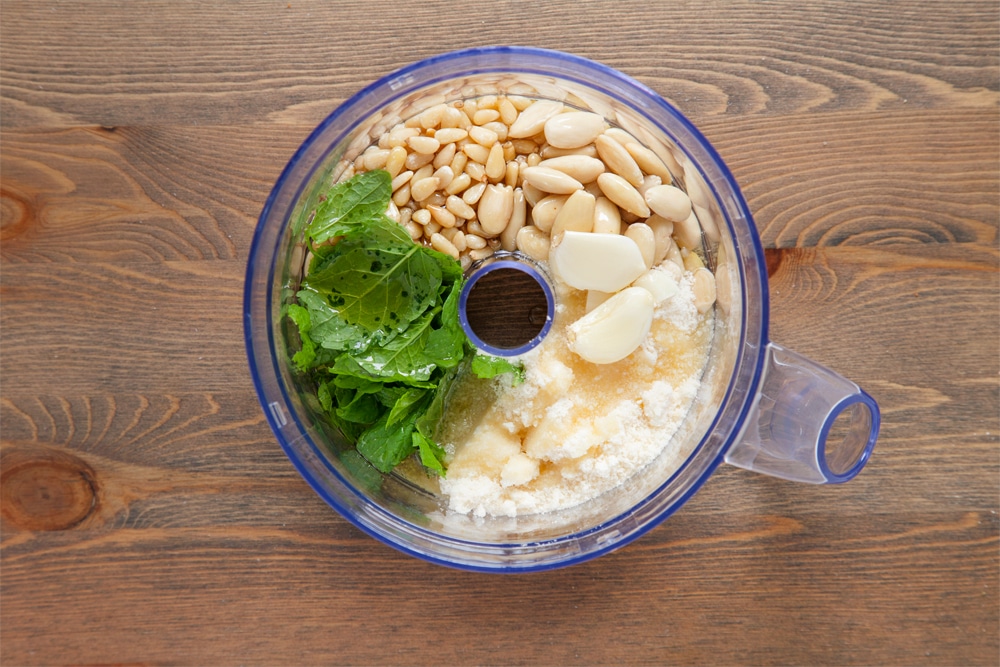 Blitzing ingredients for the pesto in a food processor