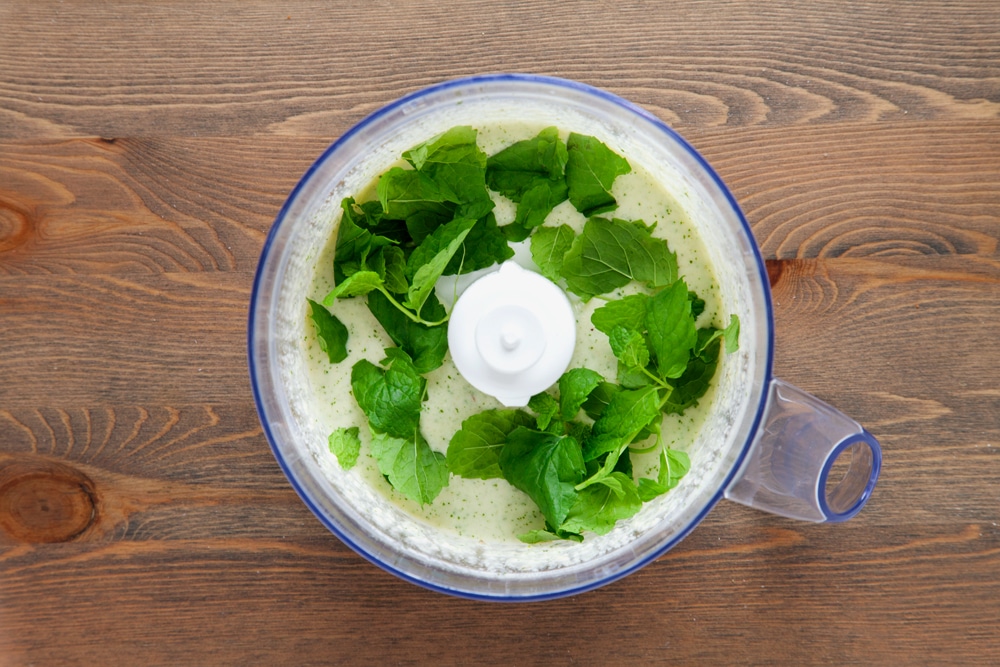 Blitzing ingredients for the pesto in a food processor