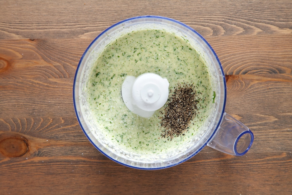 Blitzing ingredients for the pesto in a food processor