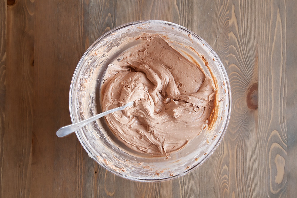 To make the kitty cake pops we start by adding multiple ingredients into a bowl and mixing.