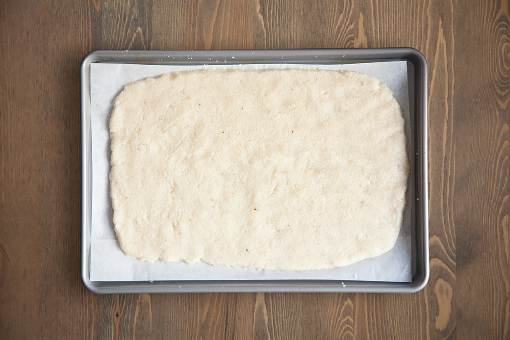 Preparing the cauliflower crust base for baking