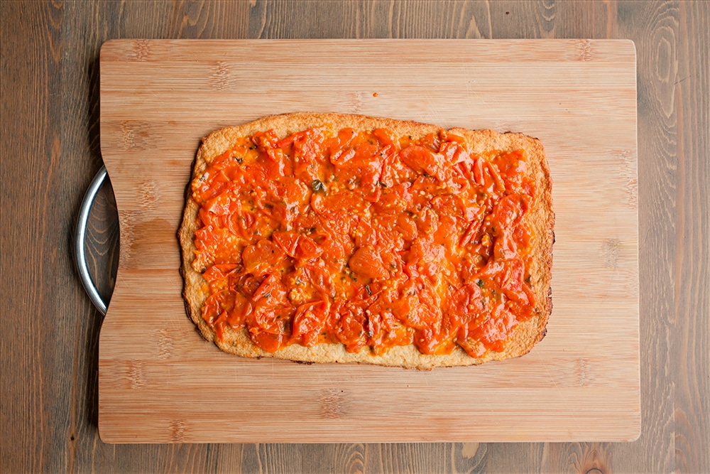 Assembling the Grana Padano and Prosciutto di San Daniele cauliflower crust pizza