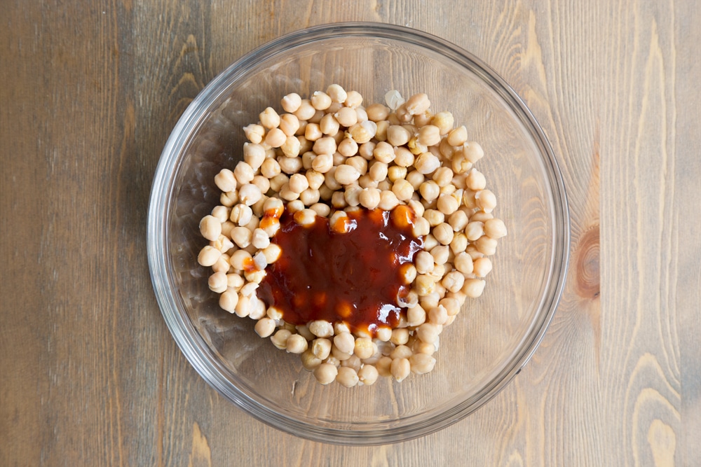 BBQ sauce shown on top of chickpeas, ready to be mixed in to add flavour