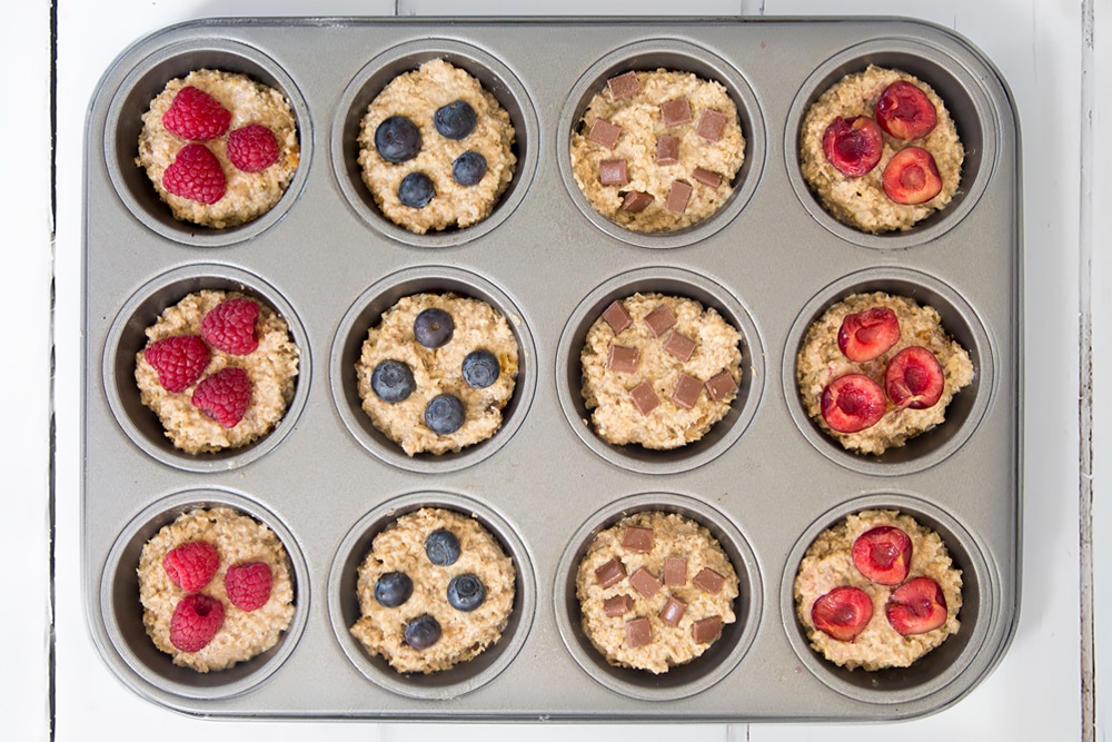 The yogurty breakfast muffins are ready to bake! Shown here topped with raspberries, blueberries and chocolate chips