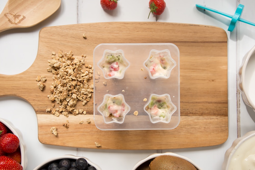More yogurt mix is added on top of the granola, creating a layered frozen yogurt lolly