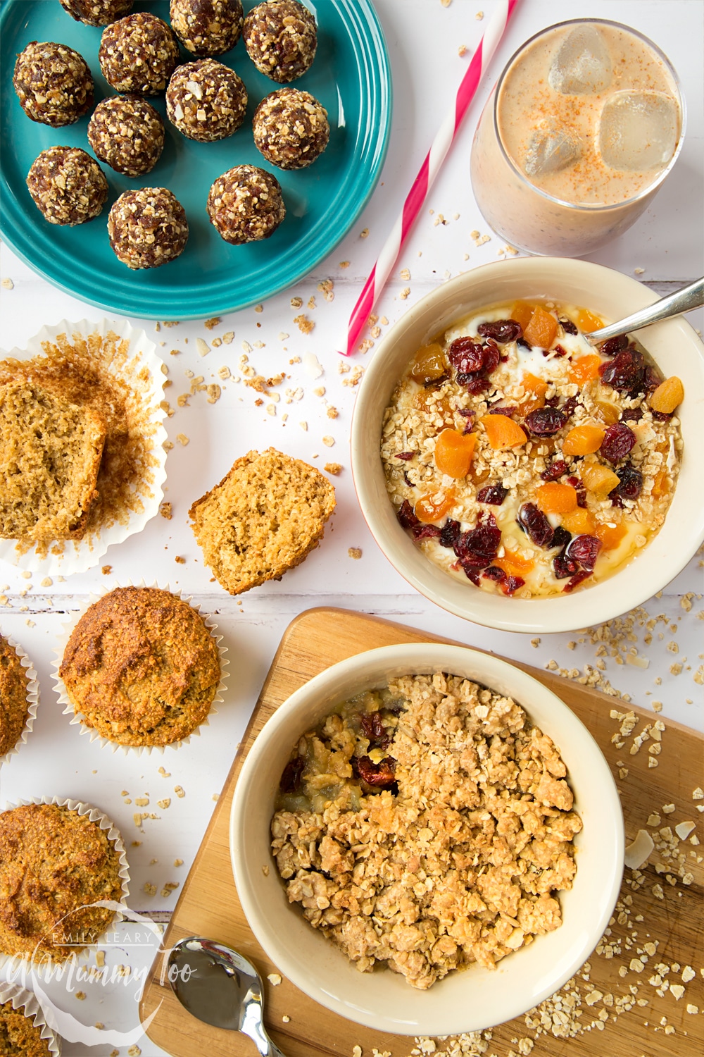 Overhead shot of two bowls filled with granola and some protien granola balls on the side served on a blue plate.
