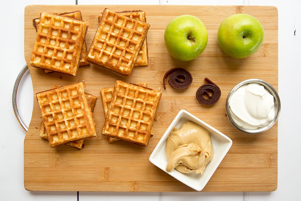 Ingredients to make the waffle apple burgers, shown on a chopping board