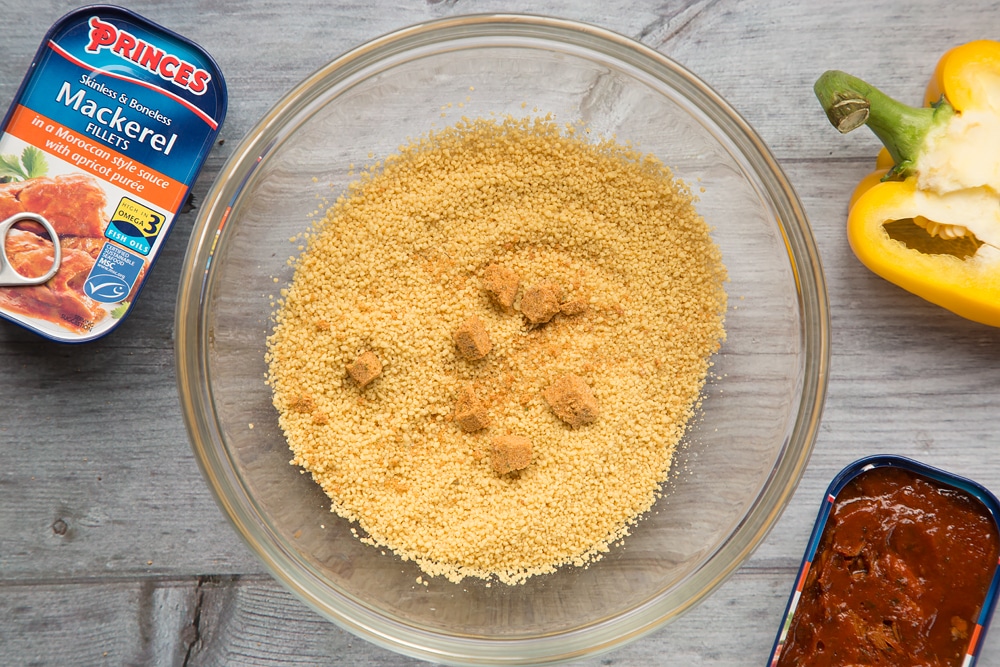 Preparing the couscous for the recipe in a bowl, with stock cubes