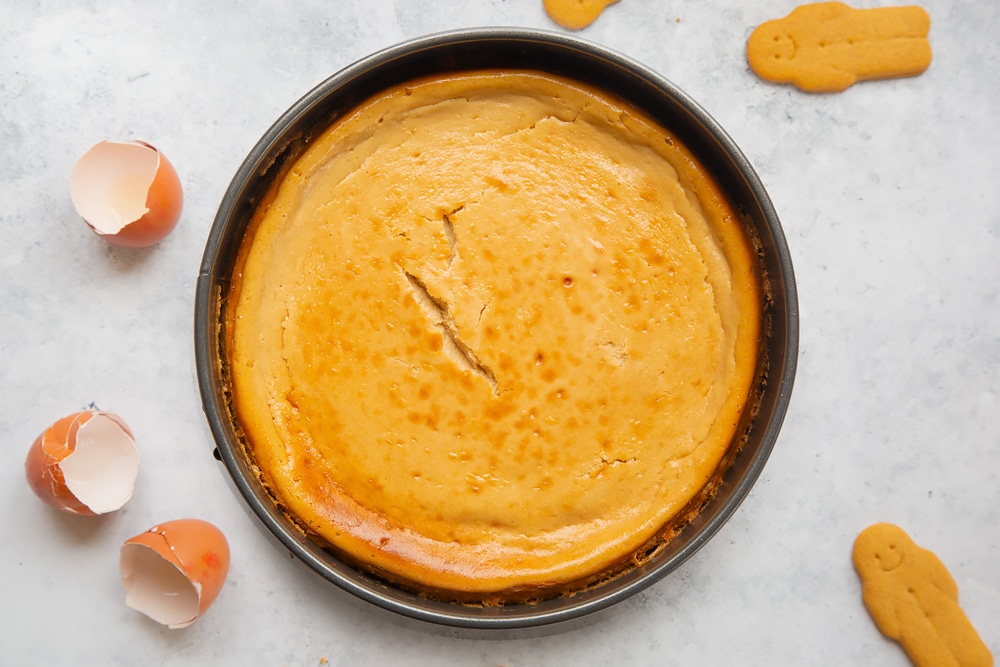 Overhead shot of freshly baked gingerbread cheesecake in a round baking tin