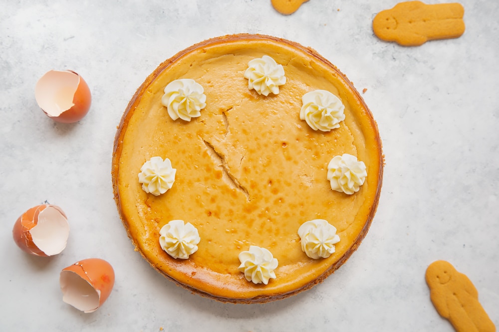Overhead shot of gingerbread cheesecake with swirls of cream on the side