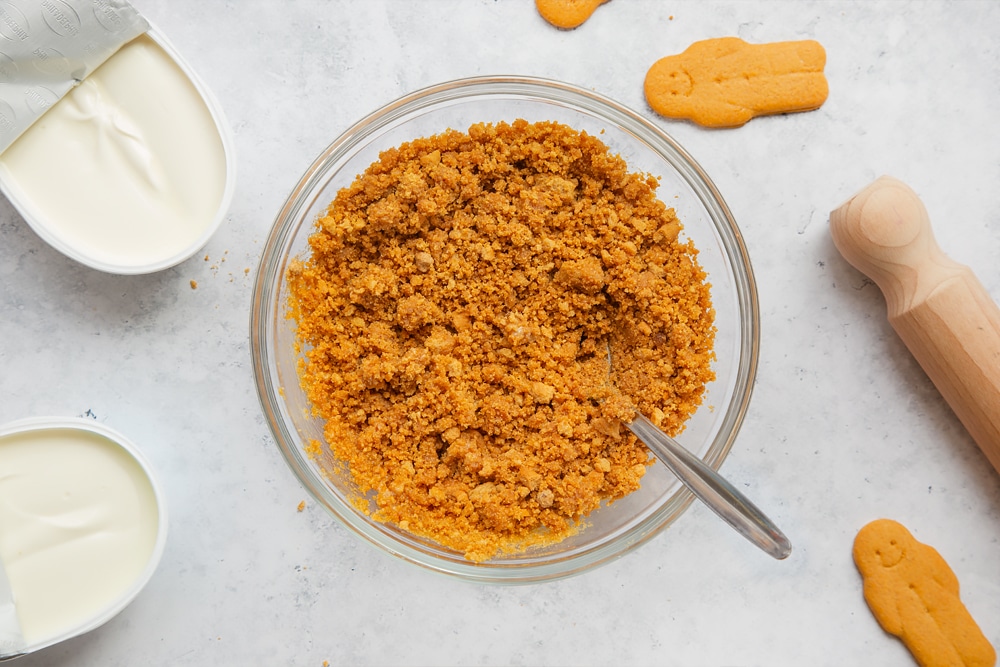 Overhead shot of crushed biscuits mix in a clear bowl