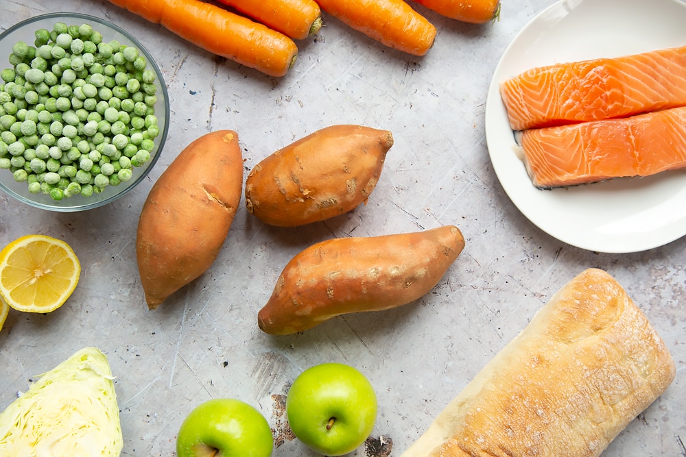 Ingredients to make this healthier fish finger sarnie - sweet potatoes, peas, salmon, bread, apples, carrots and more