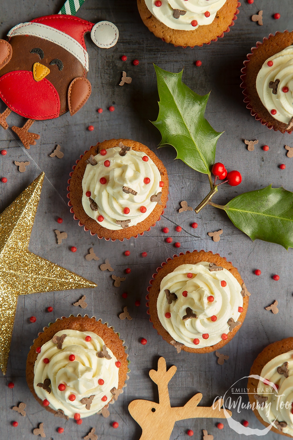 Adding festive sprinkles to the finished spiced Christmas cupcakes with marzipan frosting