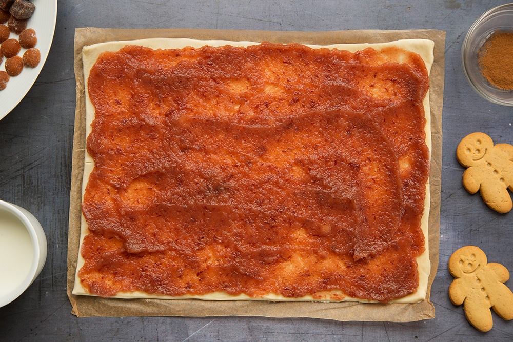 Puff pastry sheet topped with red applesauce