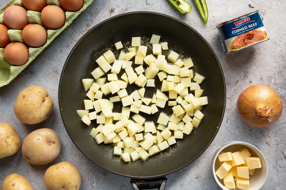 Parboiled potatoes, cubed, in a frying pan