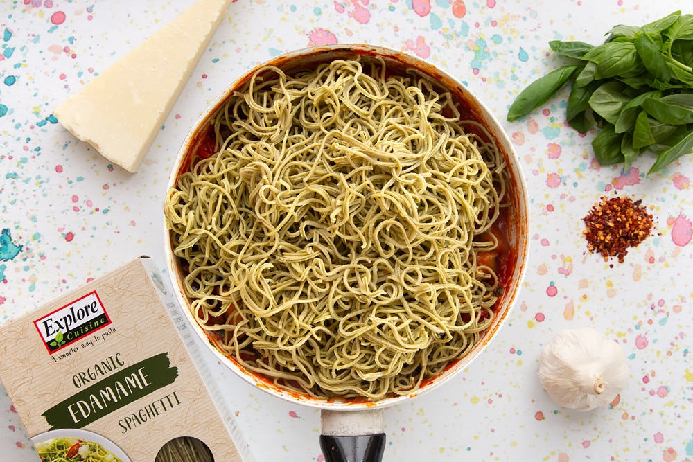 spaghetti alla norma ingredients together in a pan, with the spaghetti on top ready to be mixed