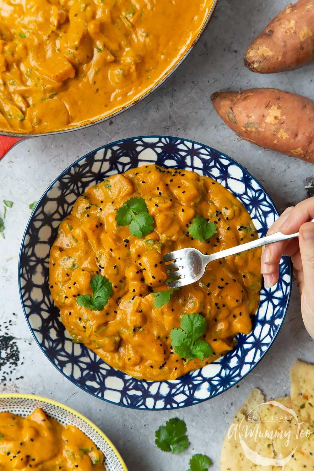 A finished bowl of butternut squash and chickpea curry served in a dark blue decorative bowl.