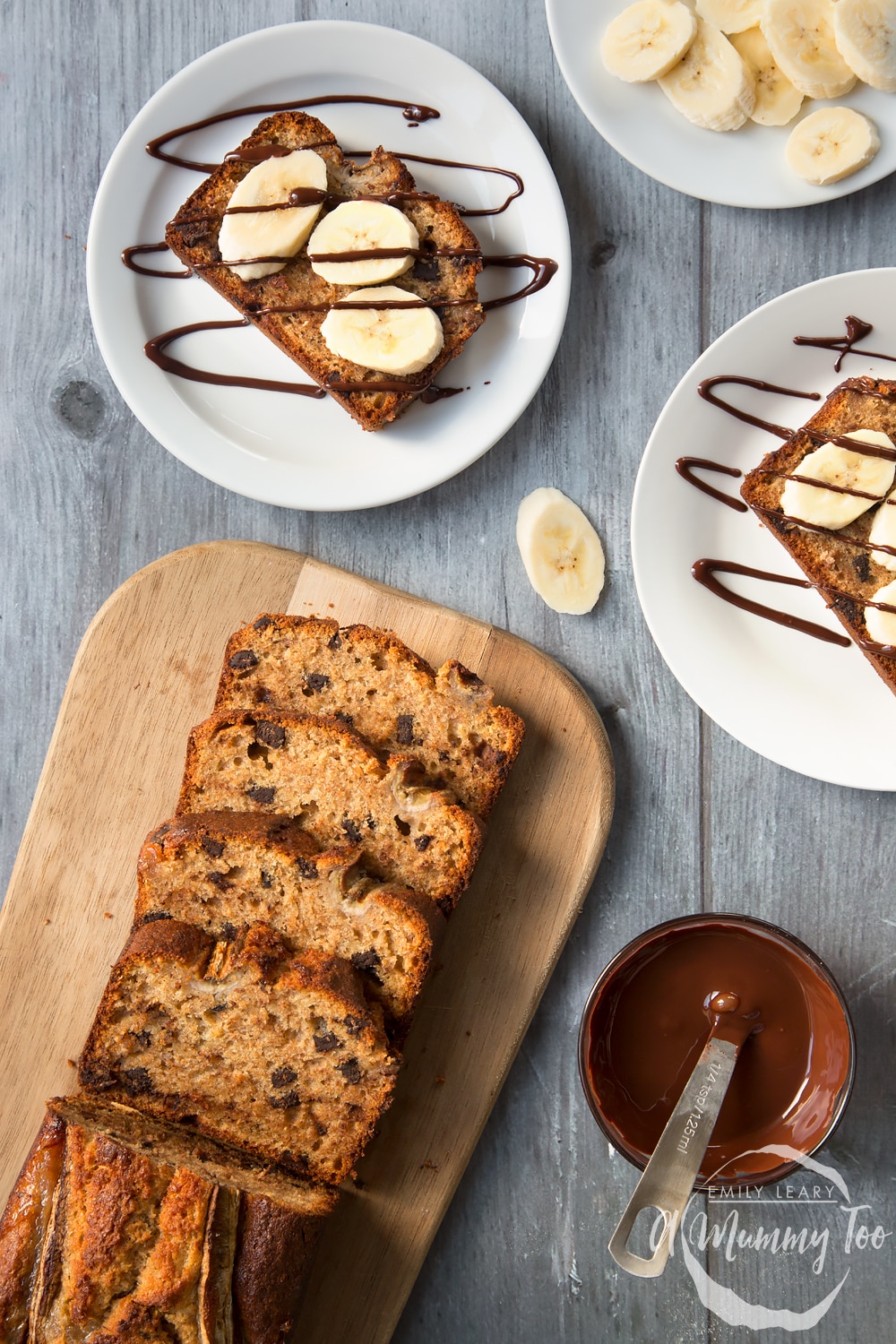 Overhead shot of Dark chocolate chip banana loaf with chocolate drizzle with a mummy too logo in the lower-right corner