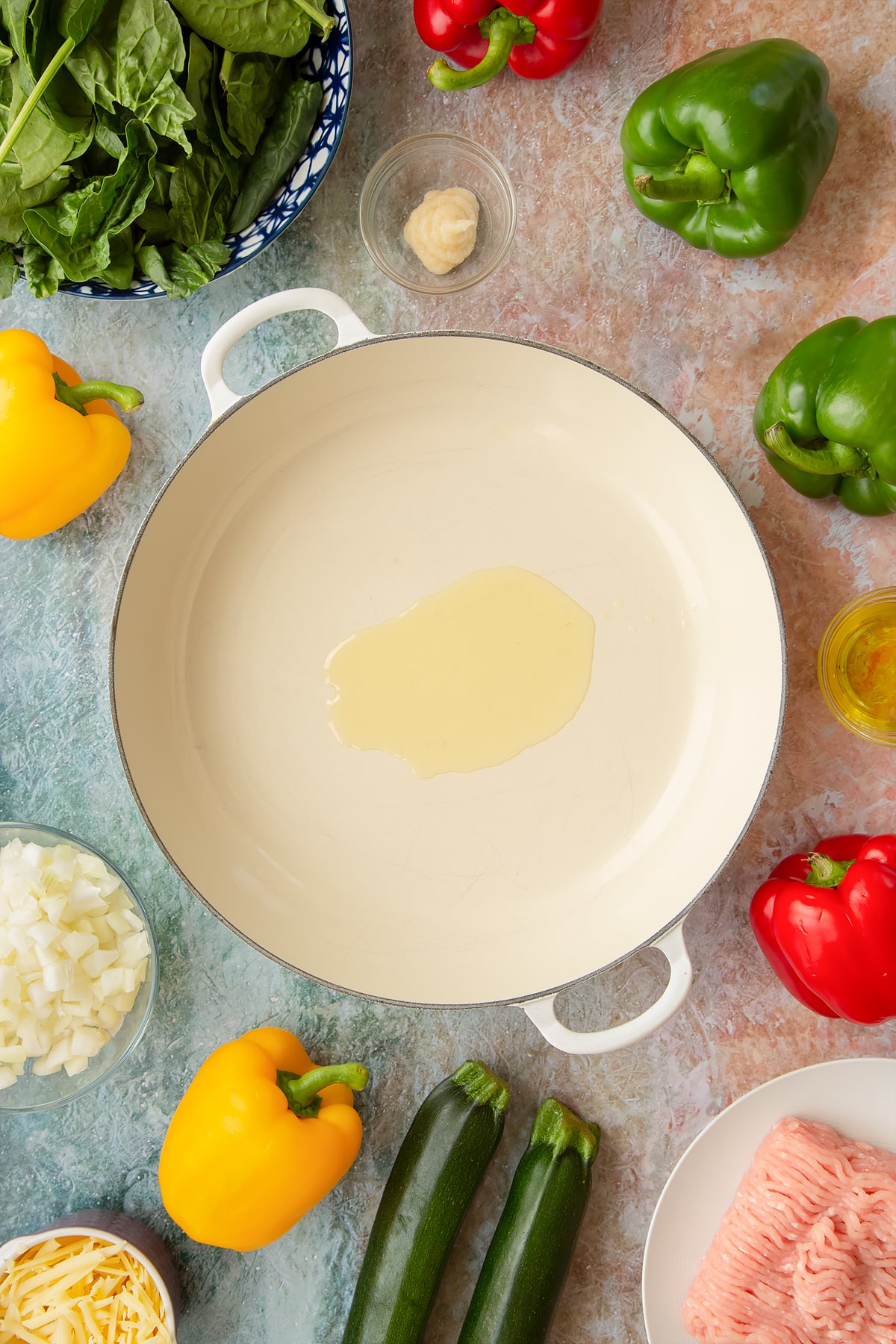 Oil in a large shallow pan. Ingredients to make baked bean stuffed peppers surround the pan.