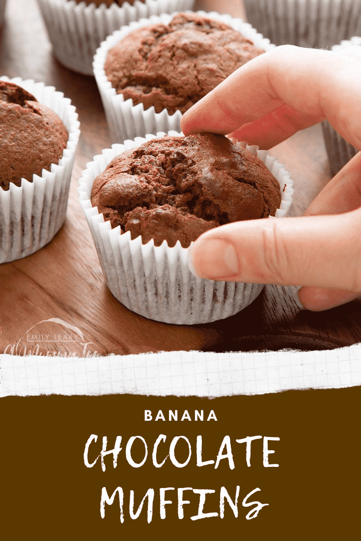 Graphic text BANANA CHOCOLATE MUFFINS below front angle shot of a hand holding a half eaten a banana and chocolate muffins