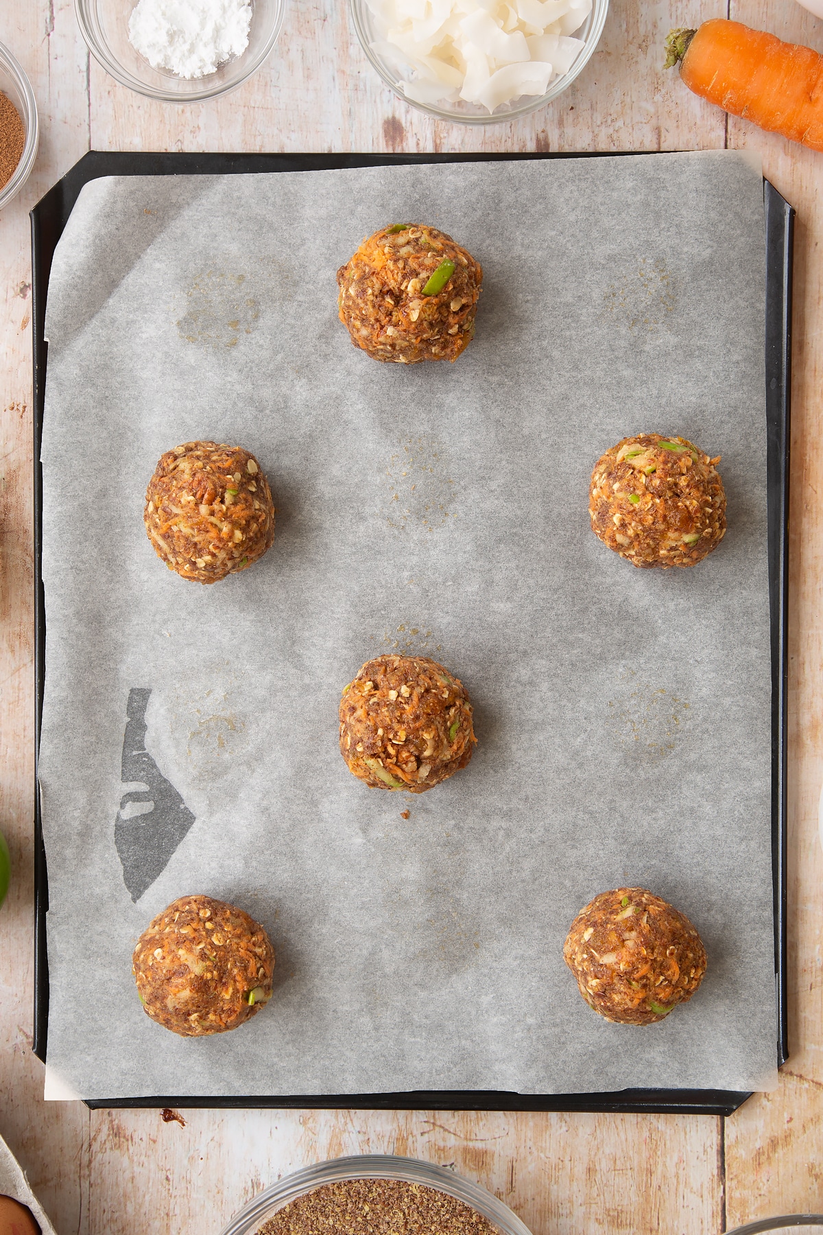 Front angle shot of a hand holding Superfood breakfast cookies served on a wooden board with a mummy too logo in the lower-left corner