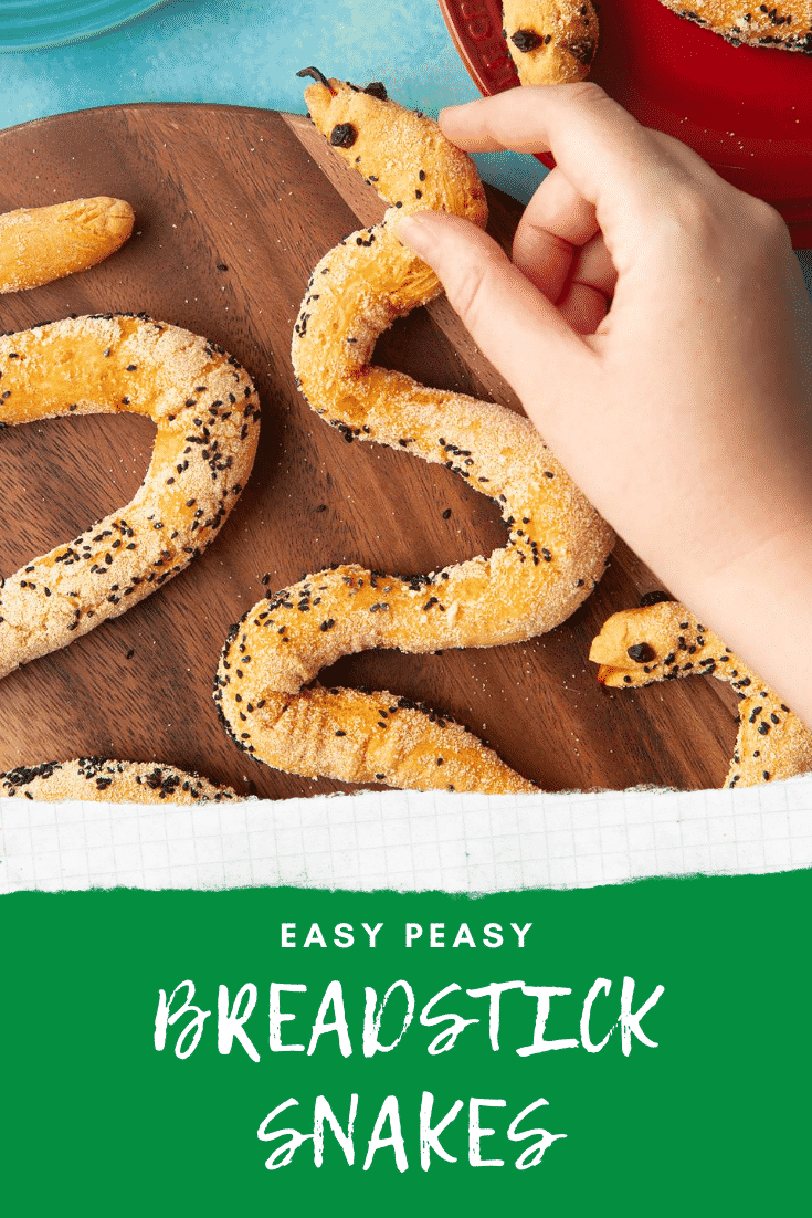 Bread snakes on a wooden board. A hand reaches for one. Caption reads: Easy peasy breadstick snakes.