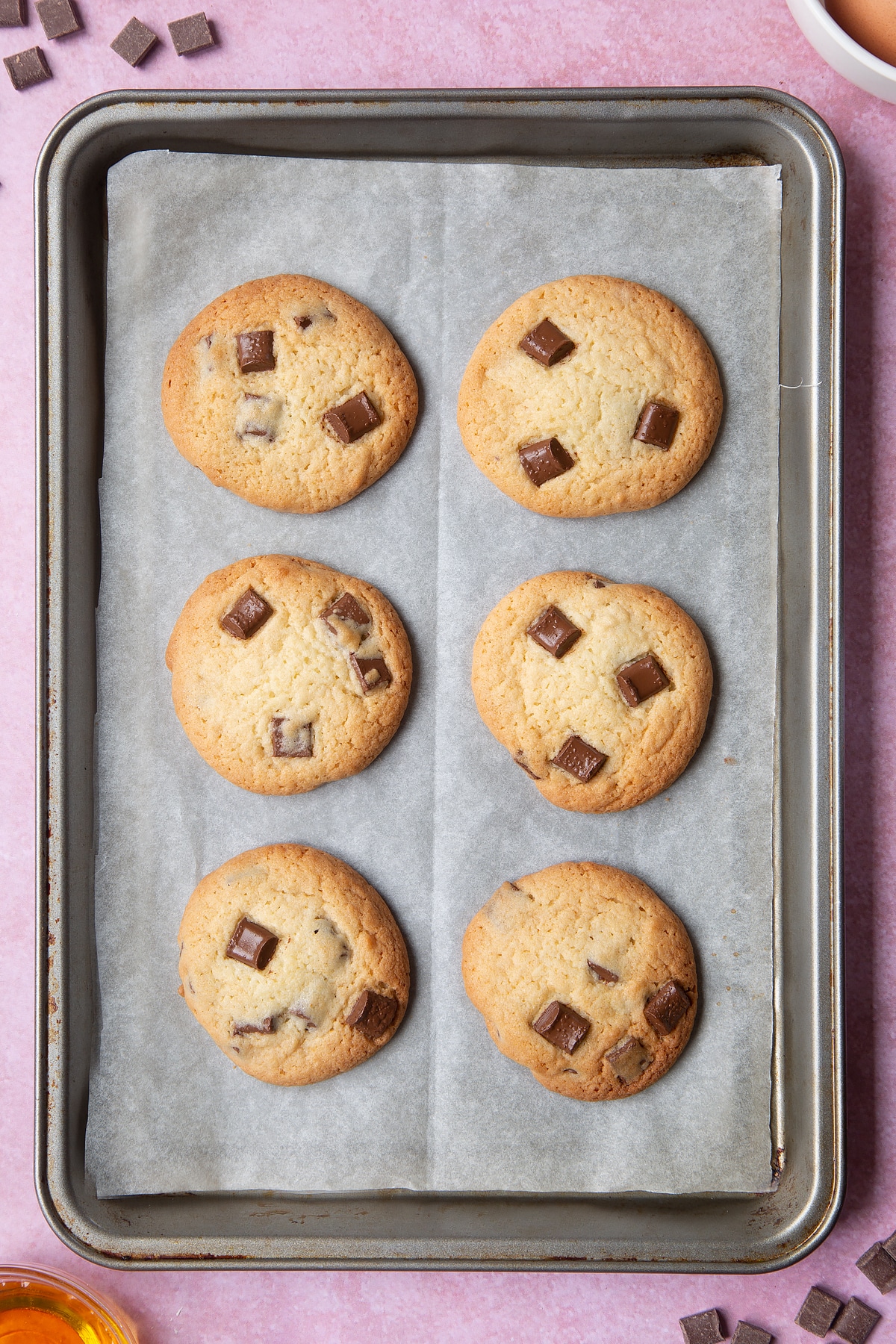 Overhead shot of finished cookies on a baking tray cooling after being in the oven.