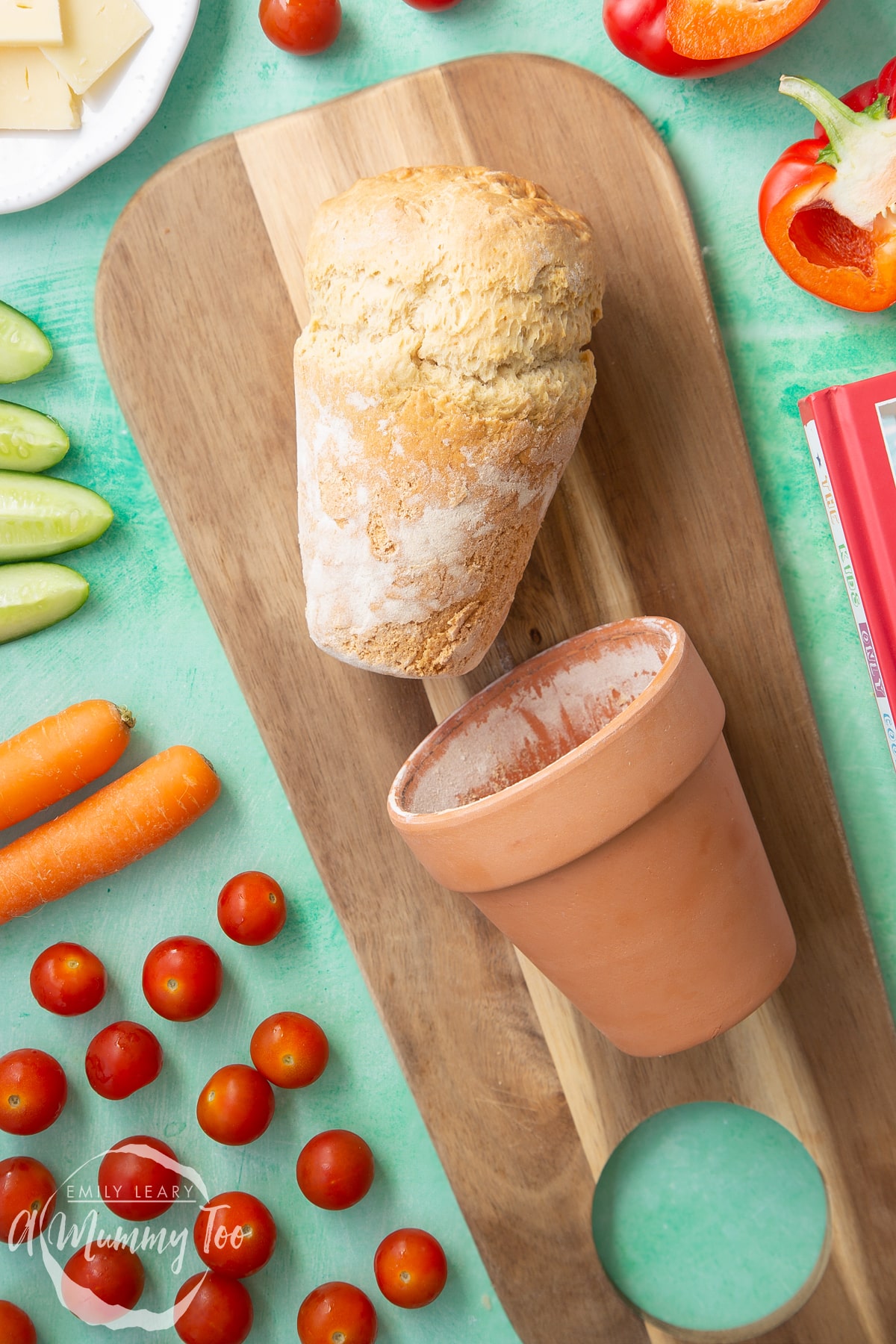 Overhead shot of Flowerpot bread being removed from the flowerpot on a wooden plate