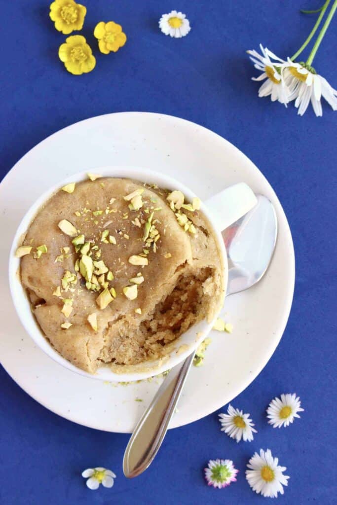 3-ingredient vegan biscoff mug cake topped with chopped pistachios.