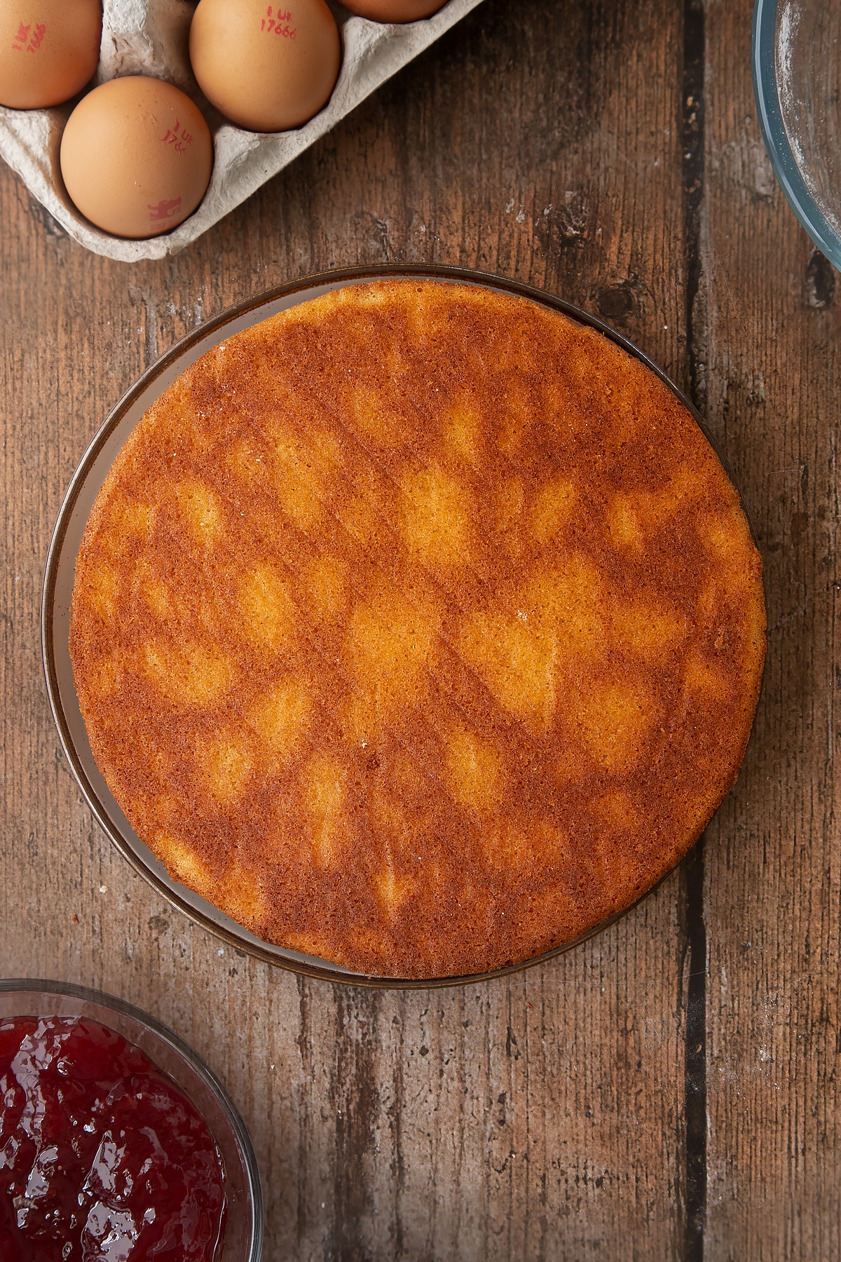 Overhead shot of Golden sponge cake on a wooden table.